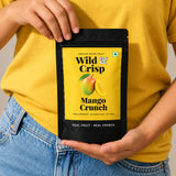 Holding a pouch of Wild & Crisp Mango Crunch