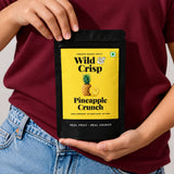 Holding a pouch of Wild & Crisp Pineapple Crunch